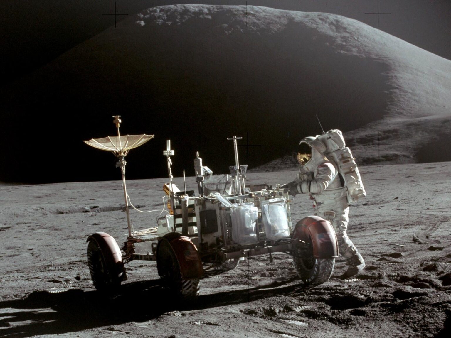 Lunar Module Pilot Jim Irwin is seen with the Lunar Roving Vehicle, with Mount Hadley in the background.  Taken by Commander David Scott on 31 July 1971.
