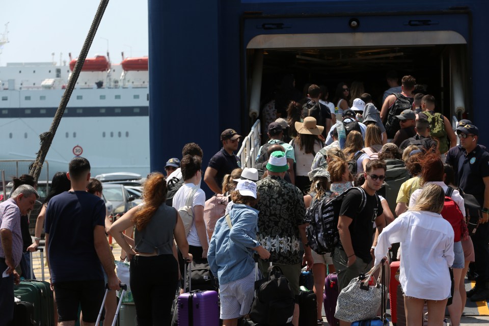 Passengers waiting at a ferry terminal with luggage.