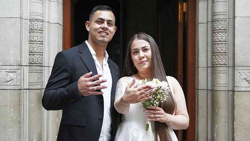 Newlyweds Magdalena Kujawińska, right, from Poland and Heinner Valenzuela from Colombia pose for photos at the Copenhagen City Hall in Copenhagen, Denmark. Wednesday 9 July 2025. (AP Photo/James Brooks)