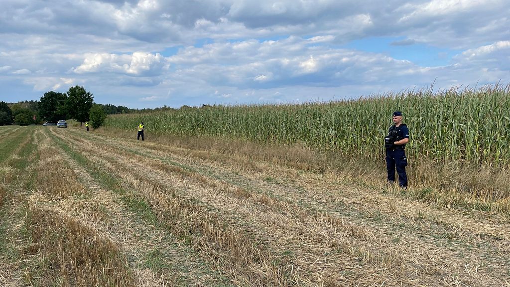 Police secure the area of a cornfield where an unidentified flying object crashed and exploded in the eastern part of the country in the town of Osiny, Poland.