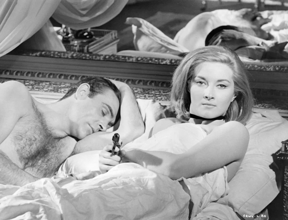 Sean Connery sleeping while Daniela Bianchi, next to him is sitting up pointing a gun in a scene from the film 'James Bond: From Russia With Love', 1963. (Photo by United Artist/Getty Images)<p><a href="https://www.gettyimages.com/detail/136558540" rel="nofollow noopener" target="_blank" data-ylk="slk:Archive Photos&sol;Getty Images;elm:context_link;itc:0;sec:content-canvas" class="link ">Archive Photos&sol;Getty Images</a></p>