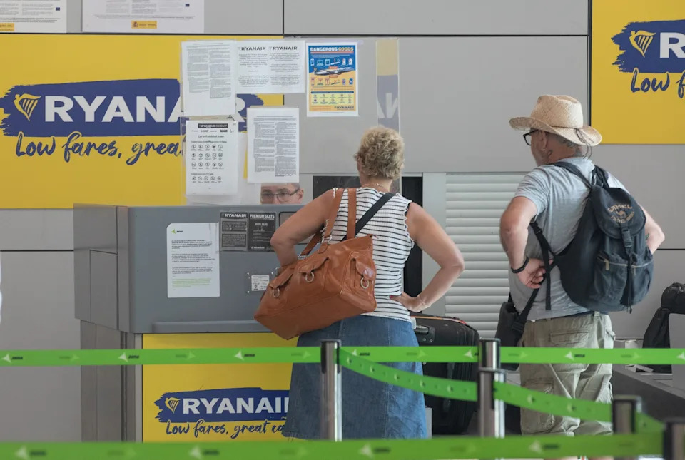 05 July 2025, Spain, Palma: Passengers stand at the Ryanair check-in counters at the airport. Due to a false fire alarm, dozens of people had to hastily leave a Ryanair plane at Palma Airport on Saturday night - via the emergency exits. Some were slightly injured. Photo: Clara Margais/dpa (Photo by Clara Margais/picture alliance via Getty Images)