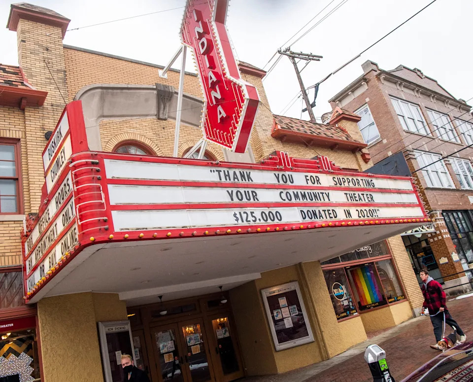 A man walks his dog under the Buskirk-Chumley Theater marquee in February 2021.