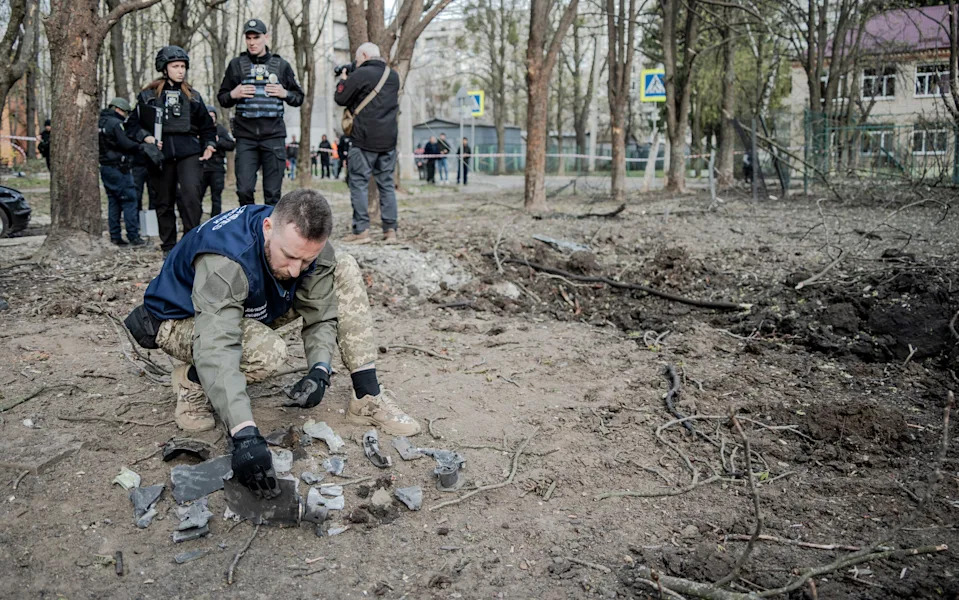 A military expert lays out on the ground fragments of a Russian UMPB D-30 glide munition found at the site of an aerial bombing of the city's residential area on April 6, 2024 in Kharkiv, Ukraine.