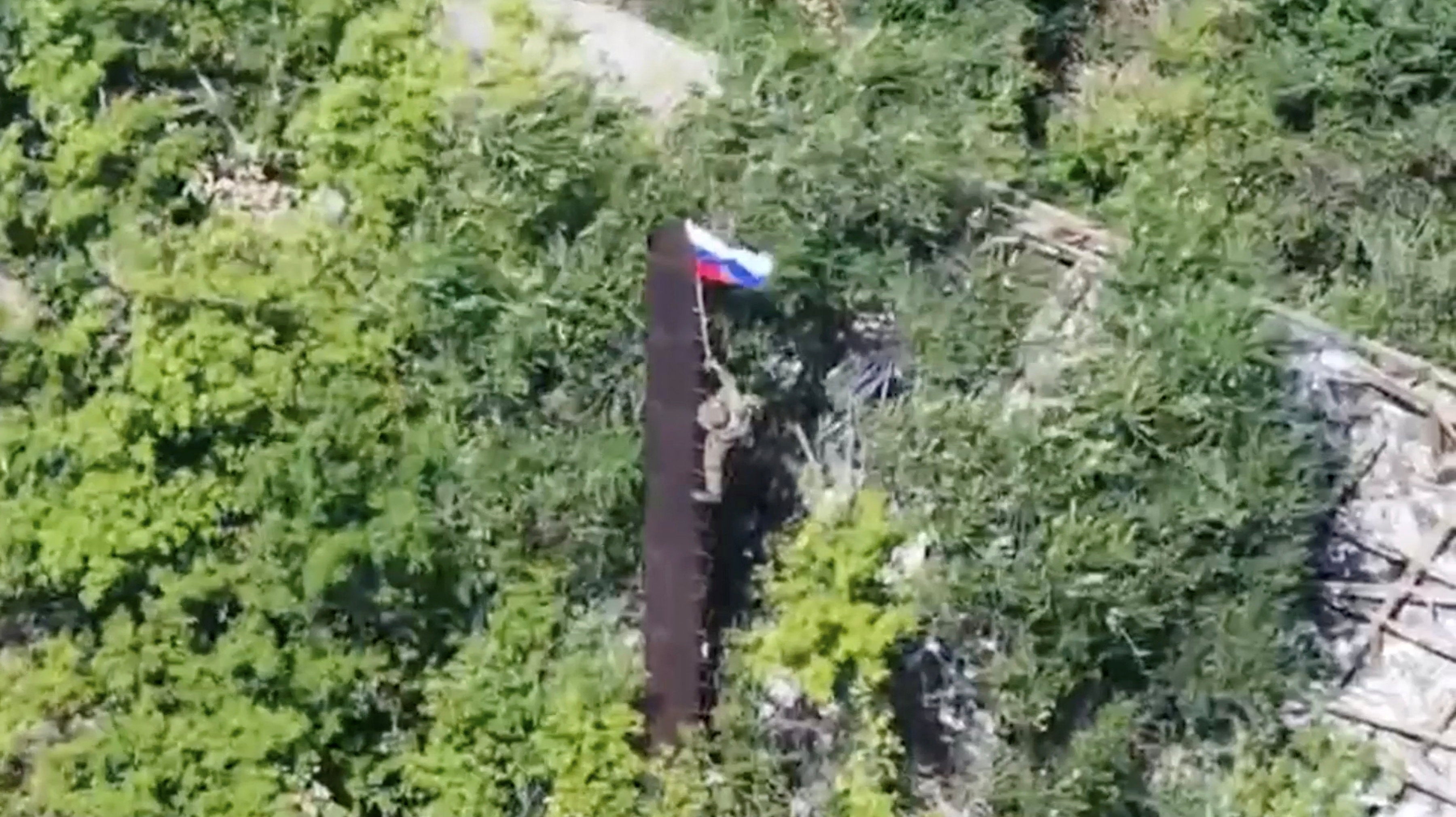 A still image, taken from footage released by the Russian Defence Ministry, shows what it said to be a Russian soldier raising a flag following the capture of Ukraine's Yablunivka (Yablonovka) settlement in the Donetsk region