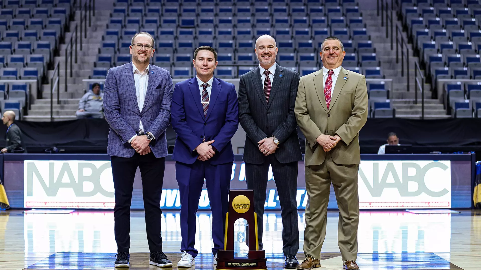 Dickey shares a moment with members of the 2024-25 Division III Men's Basketball Committee: St. Norbert Athletics Director Cam Fuller (left), former Baruch men's basketball coach John Alesi (third from left) and Penn State-Altoona men's basketball head coach David McGreal. 