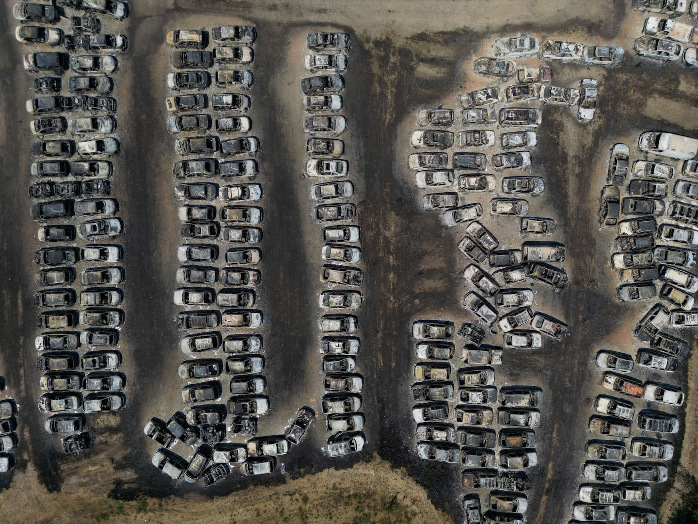 Burned cars are seen at an impound lot in Kato Achaia, during a wildfire near Patras city, western Greece, Wednesday.