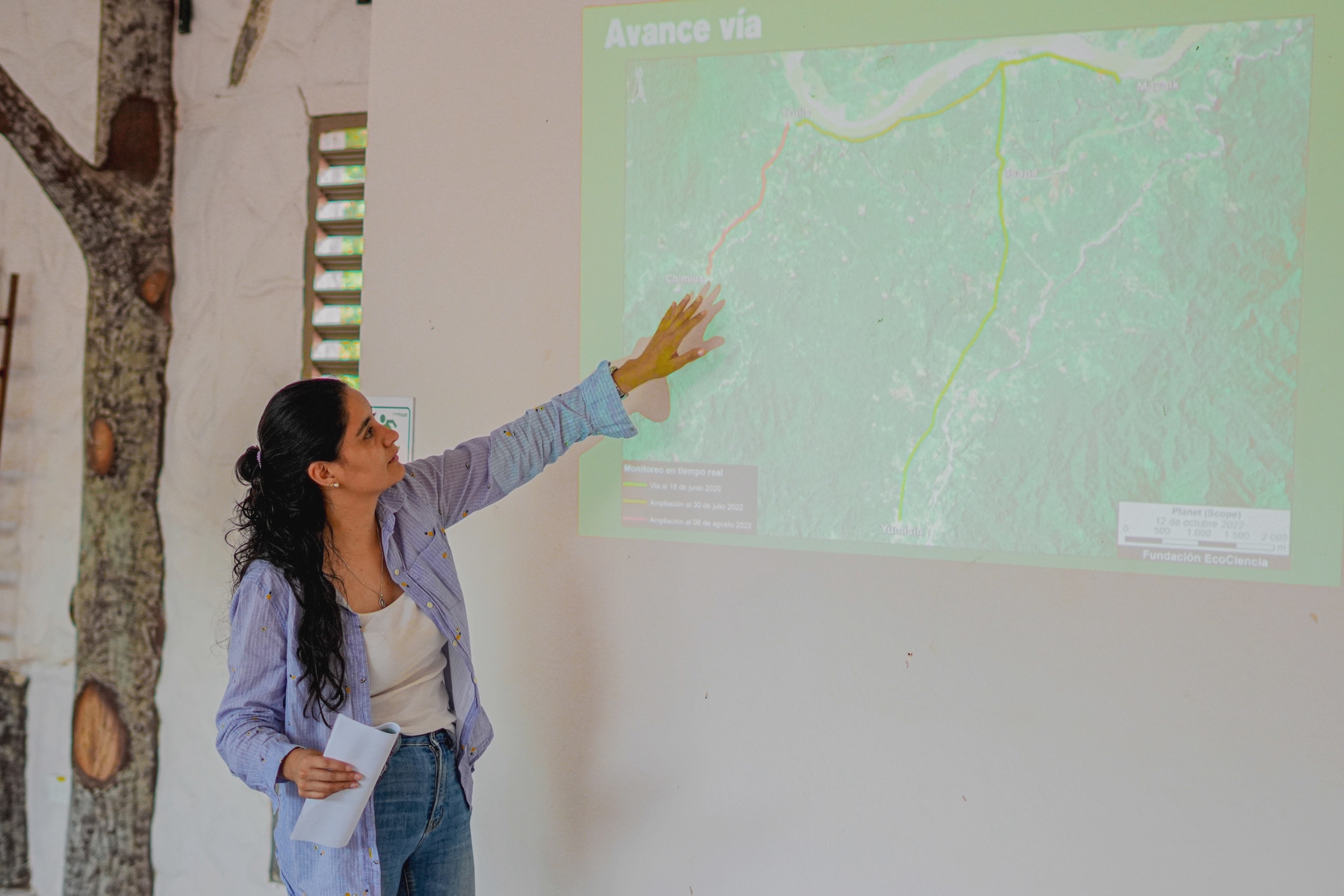 A woman points at a map displayed on a whiteboard