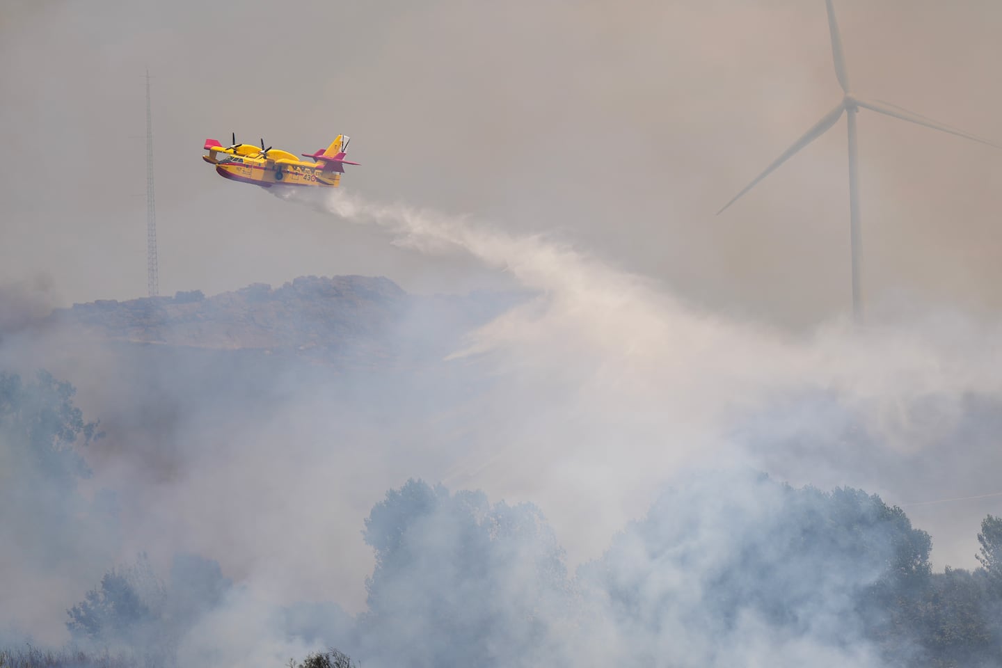 A firefighter airplane drops water on a wildfire near the village of Abejera in Zamora province on Wednesday.