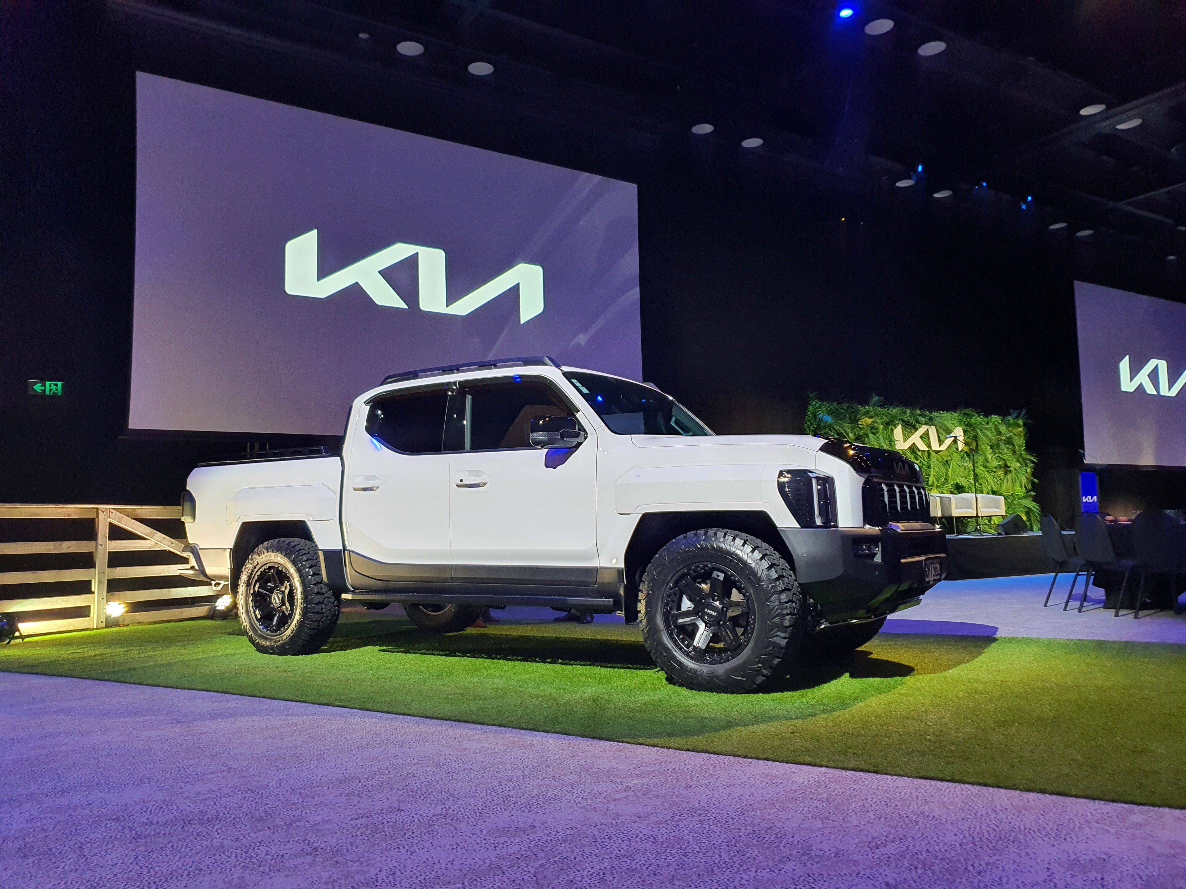 A photo of a white Kia Tasman ute parked inside Takina Events Centre in central Wellington on the launch of the 2025 Kia Tasman ute. 