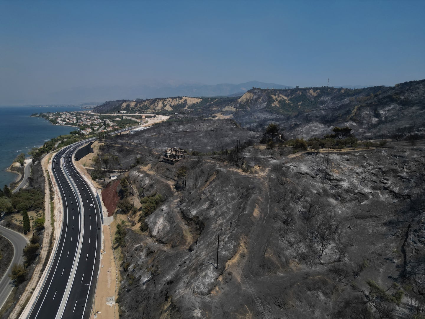 A burned hill is seen from above in Kaminia seaside village, during a wildfire near Patras city, western Greece, Wednesday.