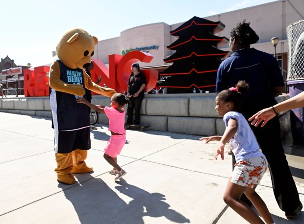 Children rush to greet mascot Healthy Berky during the Community Day at Penn Street sponsored by the Berks Community Health Center on Saturday, Aug. 9, 2025. (BILL UHRICH/READING EAGLE)
