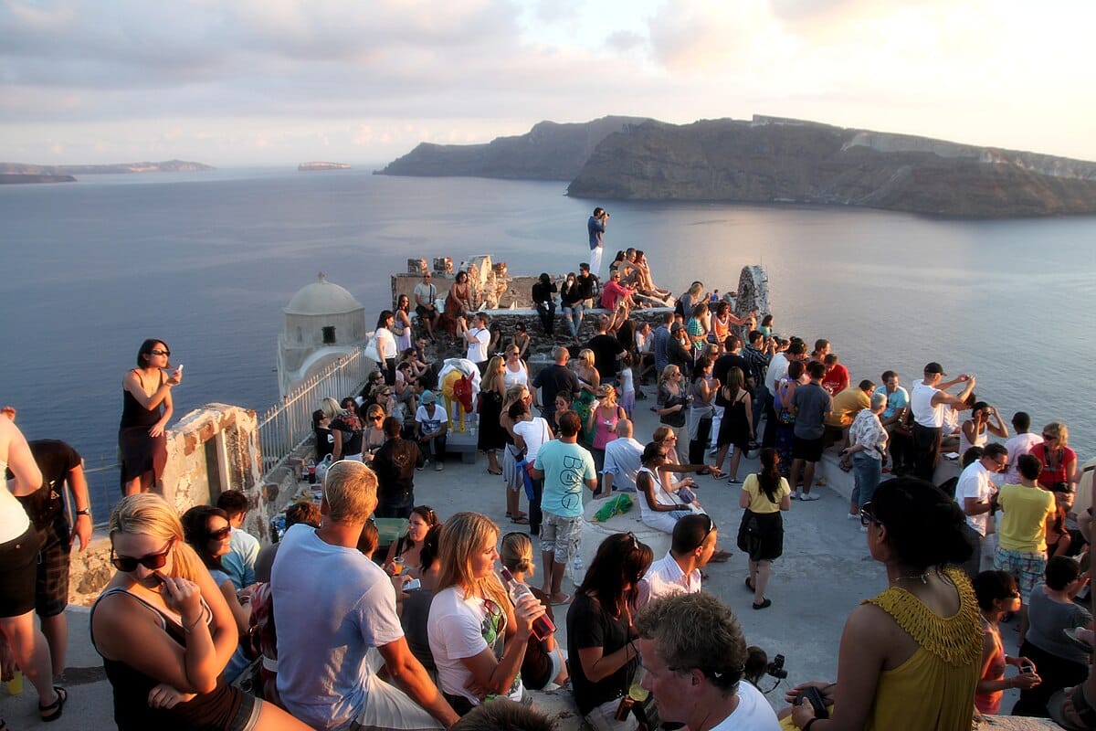 Tourists gathered to watch Santorini sunset in Greece. The tourism sector on Santorini has suffered a blow.
