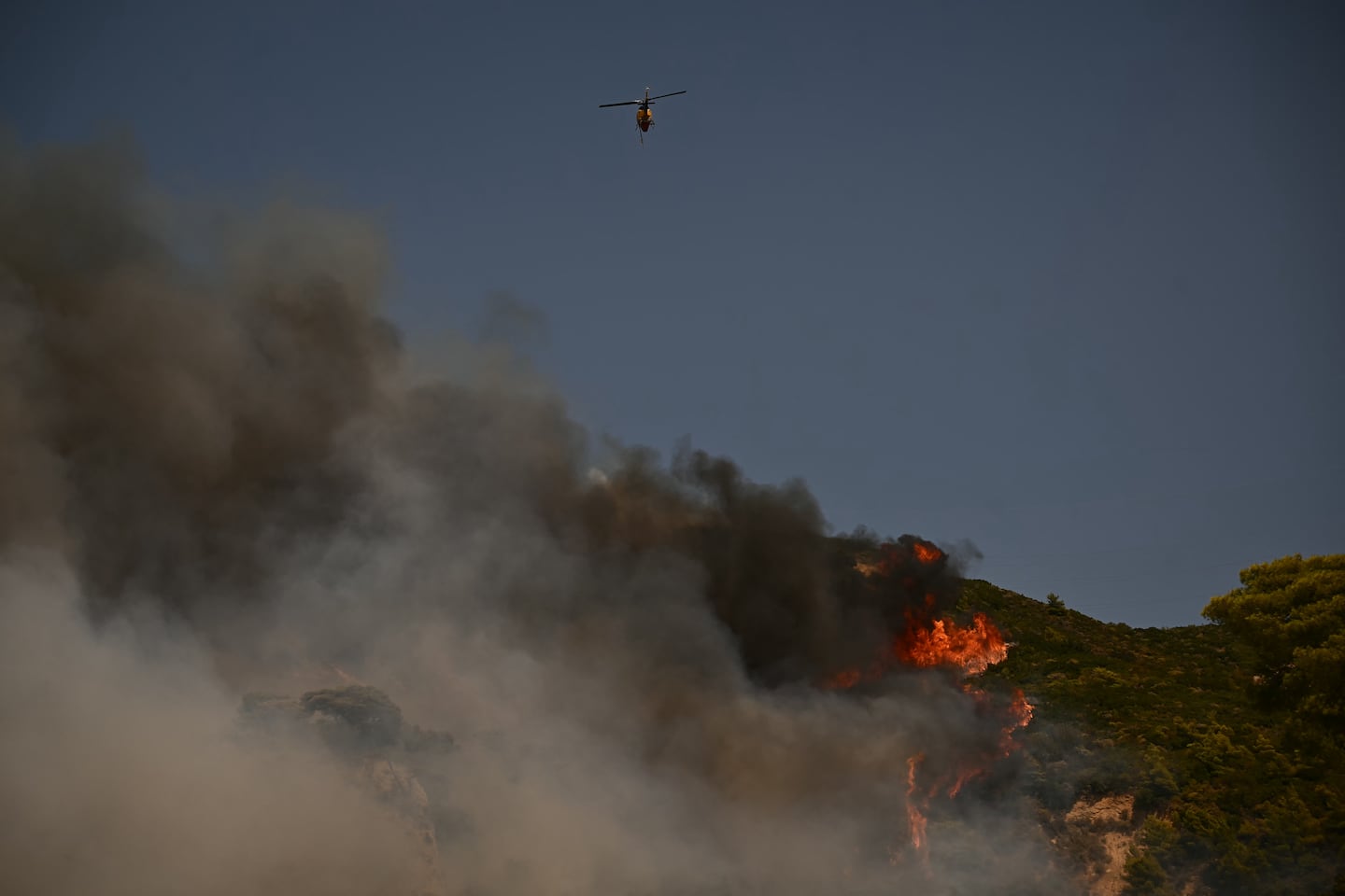 A firefighting helicopter sprayed water over a wildfire near the city of Patras, western Greece on Wednesday.
