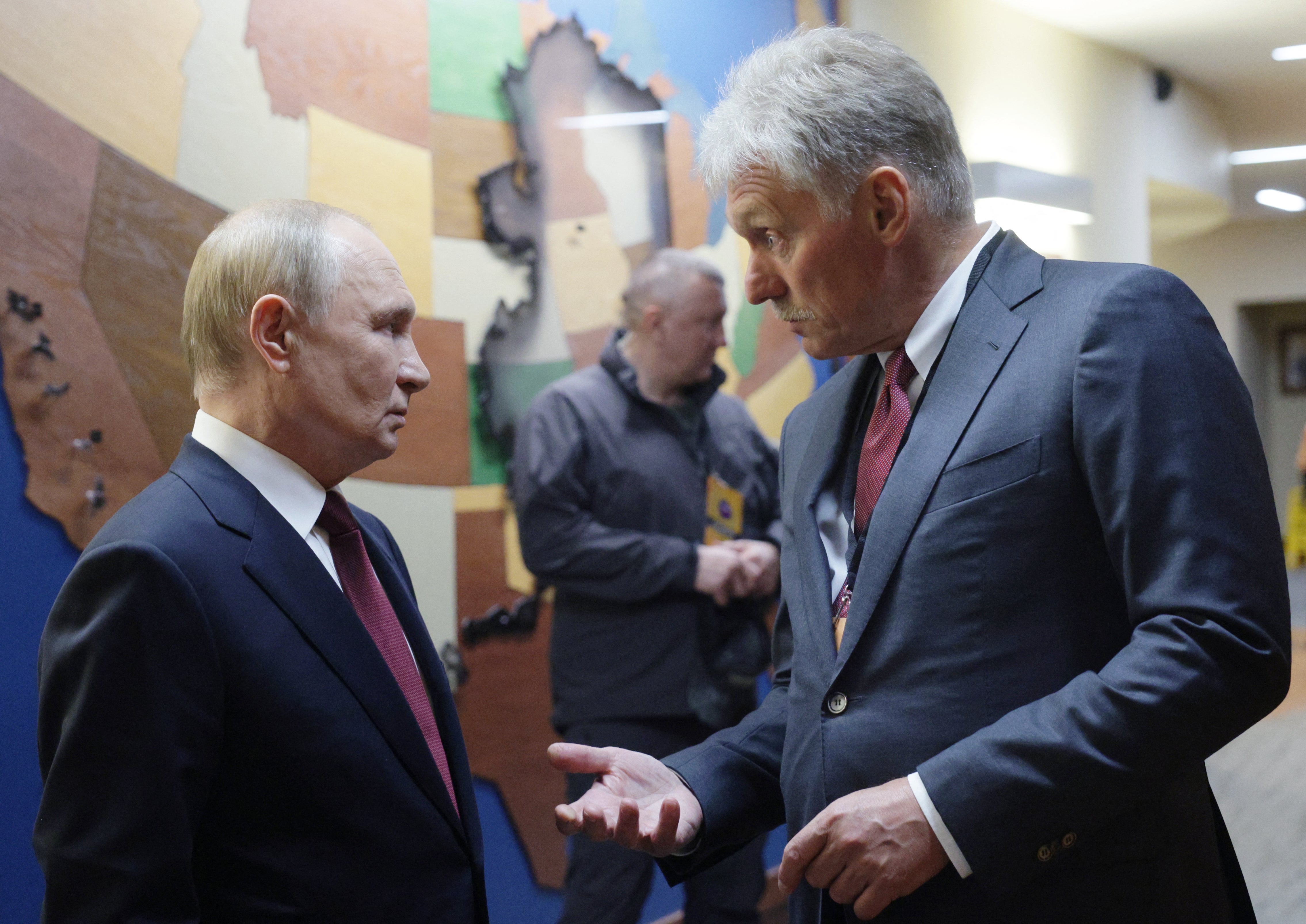 Vladimir Putin chats with Russian presidential press secretary Dmitry Peskov after a joint press conference following a US-Russia summit on Ukraine at Joint Base Elmendorf-Richardson in Anchorage, Alaska