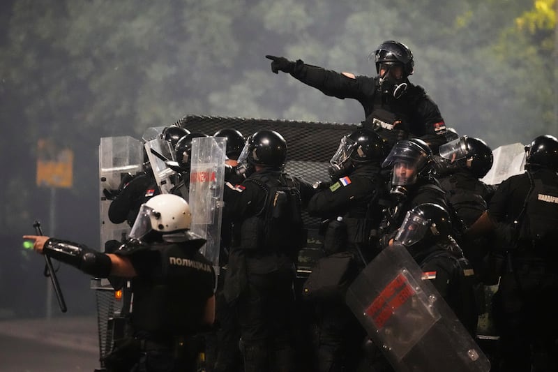 Serbian officers patrol in a truck in Belgrade (Darko Vojinovic/AP)
