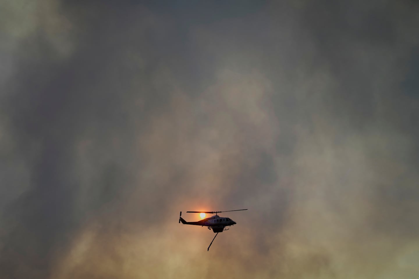 A firefighter helicopter seen flying over a wildfire in Patras city, western Greece, Wednesday.