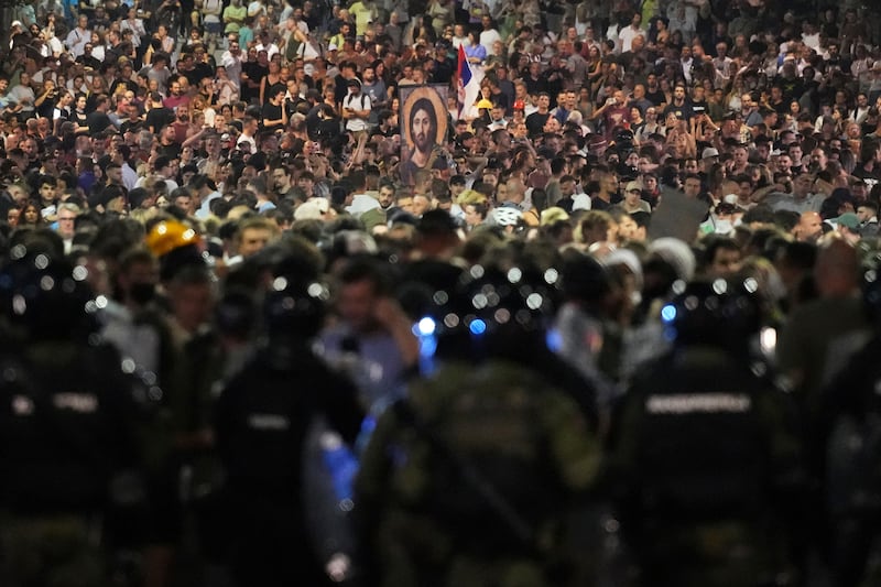 Serbian officers guard a street during an anti-government protest near the Serbian Progressive Party office in the capital (Darko Vojinovic/AP)