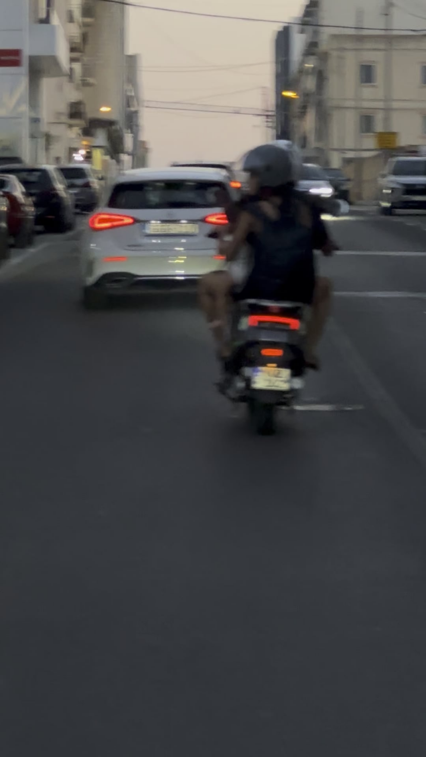 Mother holding toddler on her lap while back of the scooter