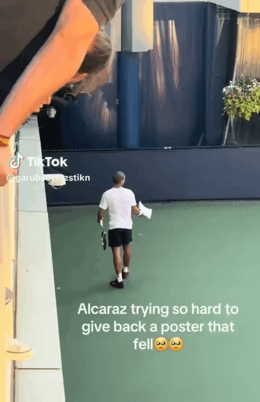 Carlos Alcaraz trying so hard to give back to the fans a poster that fell.