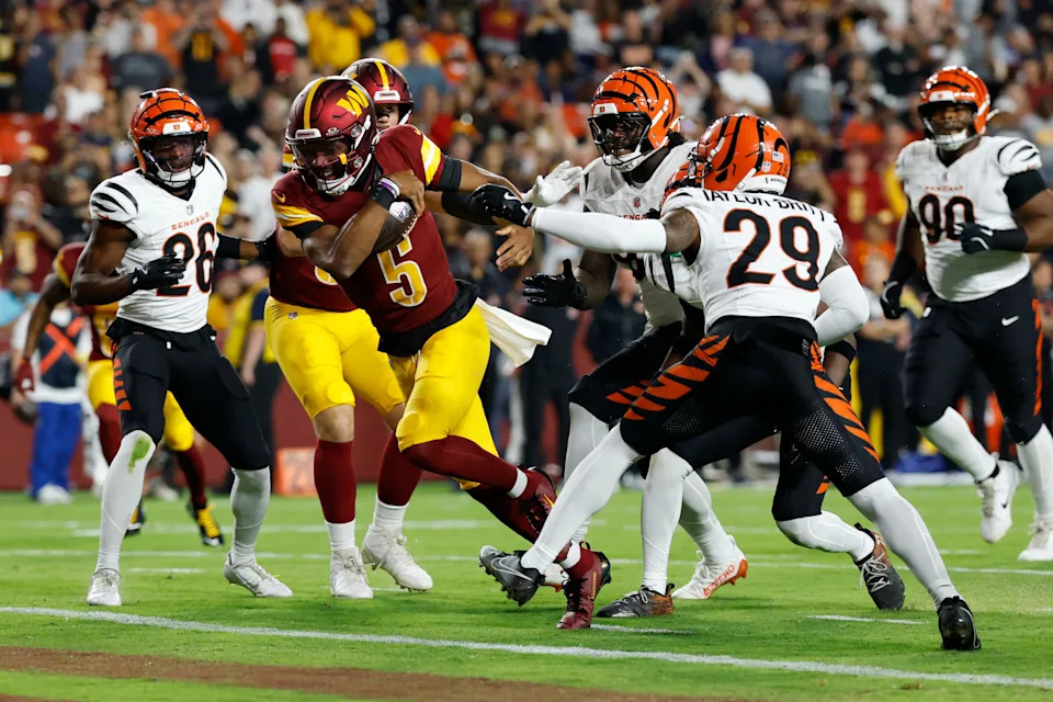 Washington Commanders quarterback Jayden Daniels runs with the ball for a touchdown against the Cincinnati Bengals defense.