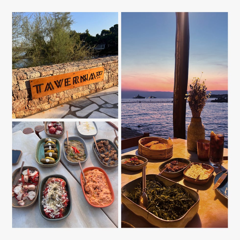 Dining setting at a seaside taverna with various dishes and a sunset view.