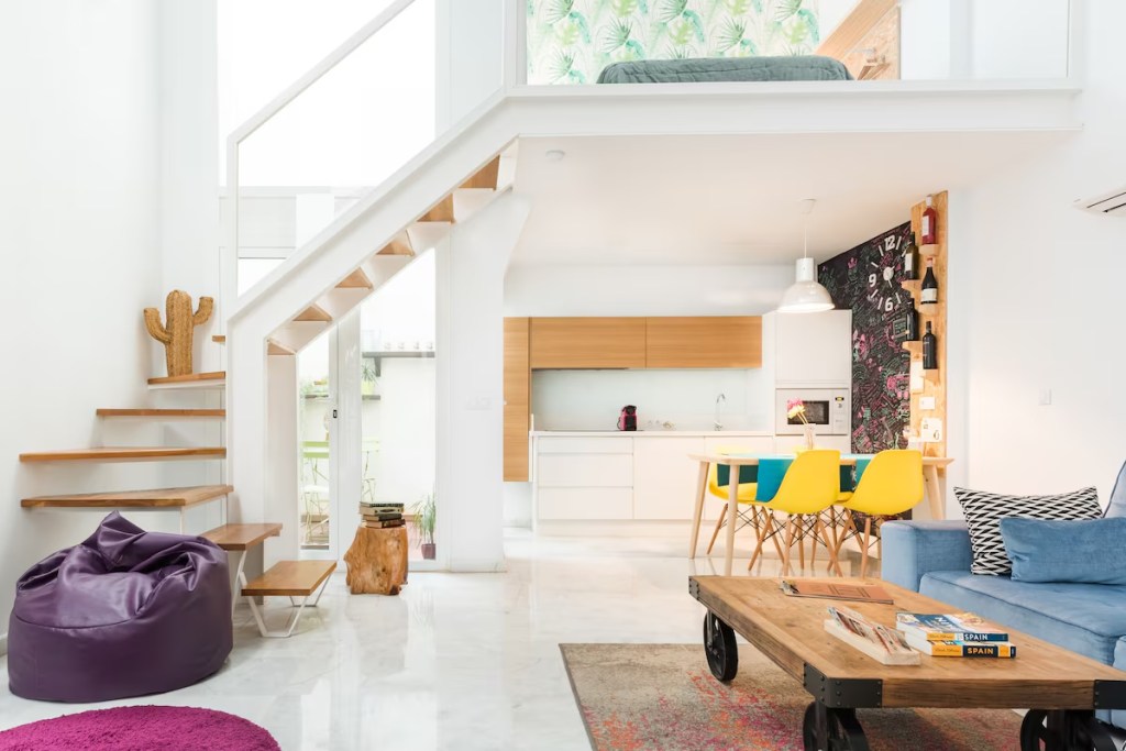 Spain Set to De-List Thousands of Unregistered Vacation Rentals Image of a loft apartment in Seville, Spain, that looks like it is out of a Pedro Moldavar artistic movie, with lots of color and modern design.