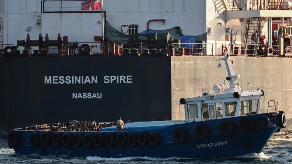 Greece To Monitor Rejected Asylum Seekers With Electronic Ankle Bracelets ━ The European Conservative Migrants stand on board a boat after disembarking from a cargo ship before being transferred in the port of Lavrio, south of Athens, on July 10, 2025.