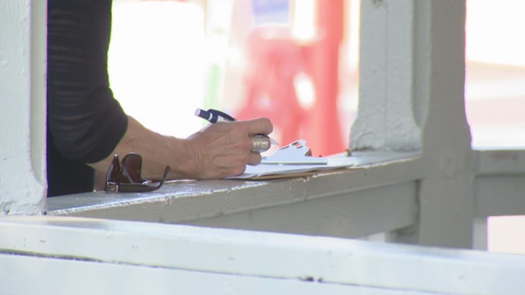 A person signs the Forever Canada petition at its kickoff in Edmonton on Saturday, Aug. 2, 2025