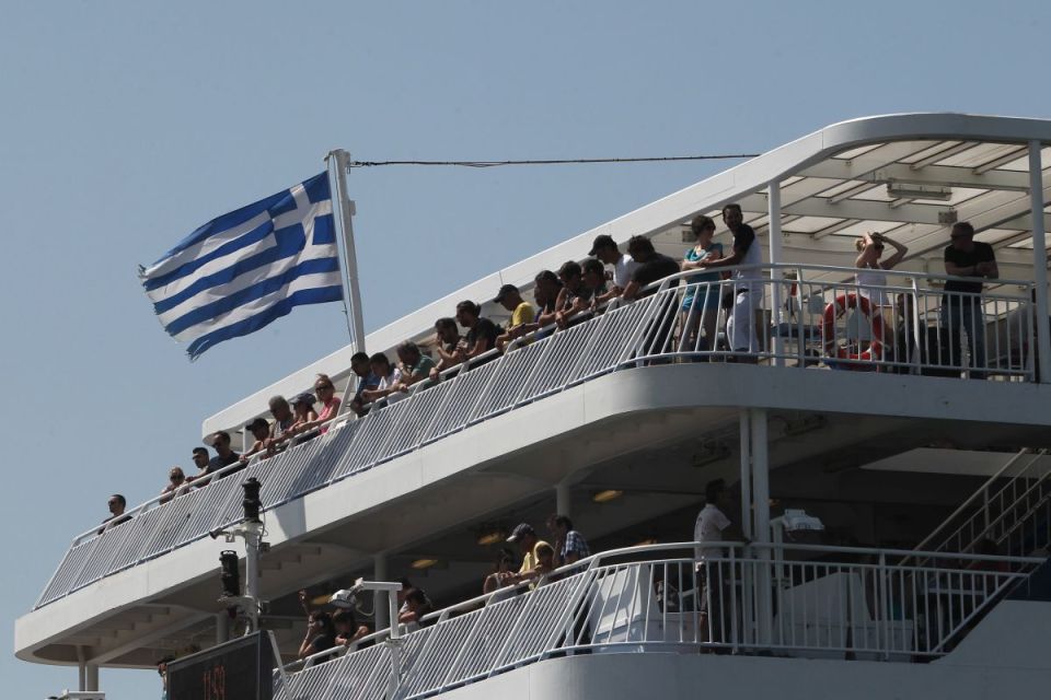 Passengers on a ferry with a Greek flag.