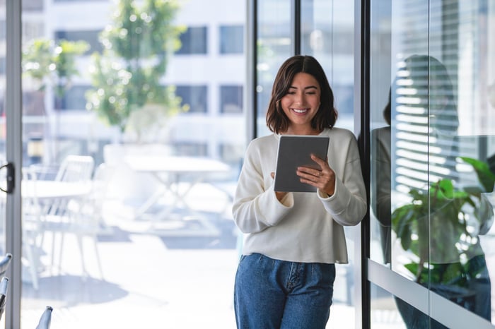 smiling investor works on a tablet.