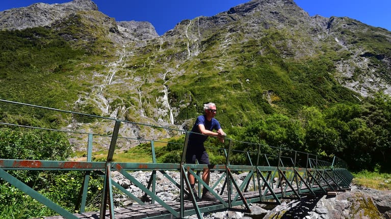 Tourist enjoying views of upper Clinton valley on Milford Track. 