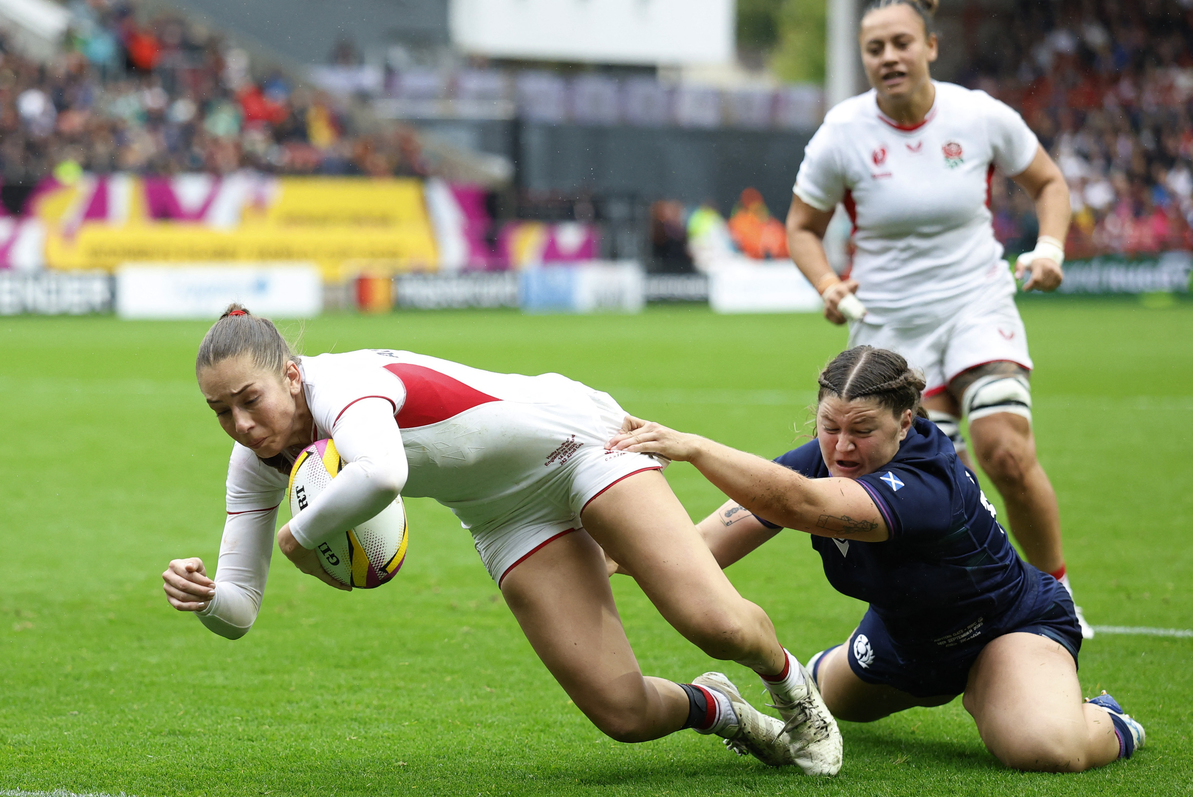 England's Holly Aitchison scores a try during a rugby match against Scotland.