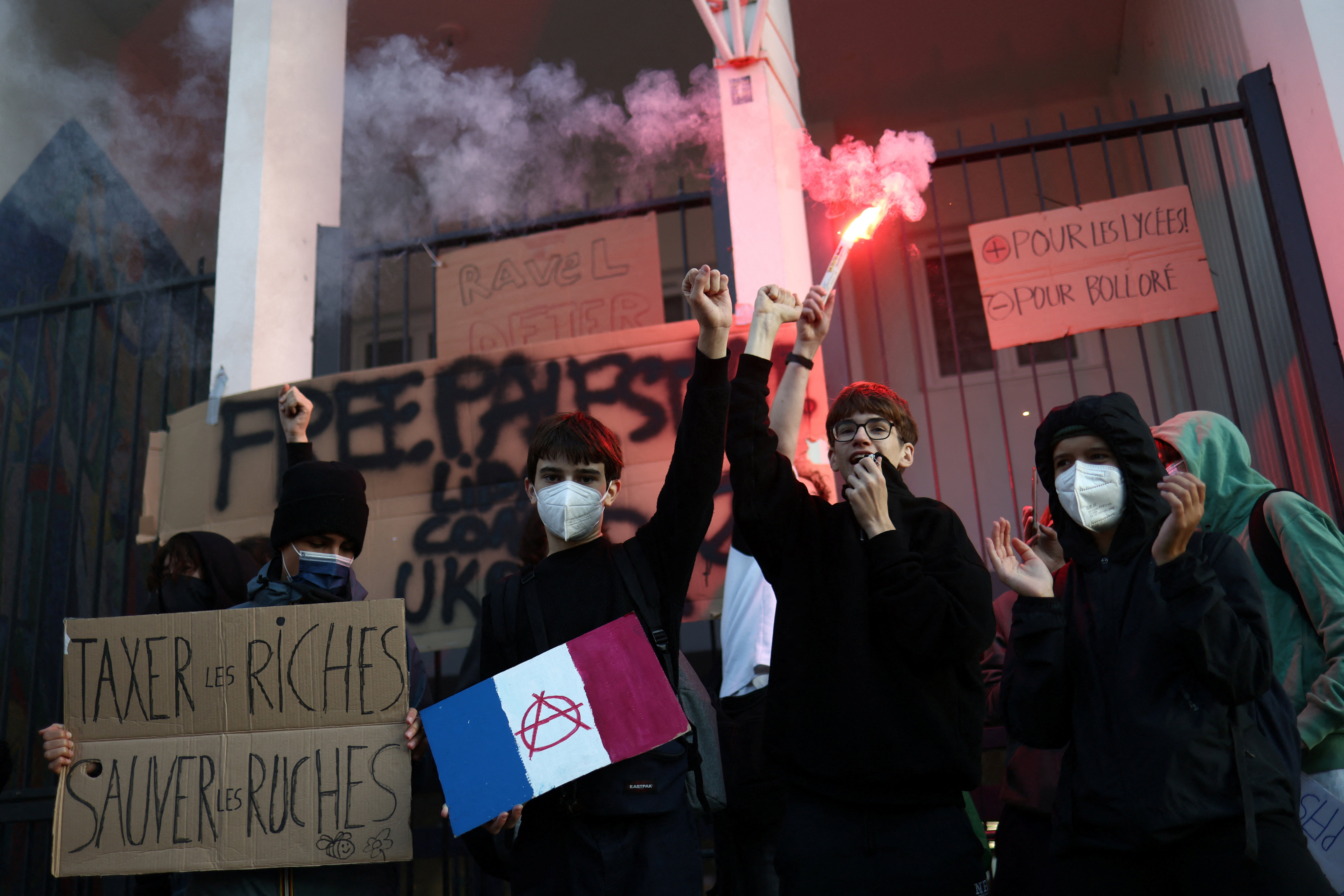 Masked French students protesting government budget cuts.