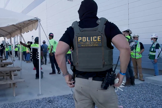 A masked federal agent wearing a Homeland Security Investigations vest guards a site during a raid where about 300 Koreans were among 475 people arrested at the site of a $4.3 billion project by Hyundai Motor and LG Energy Solution to build batteries for electric cars in Ellabell, Georgia on Sept. 4. [REUTERS/YONHAP]