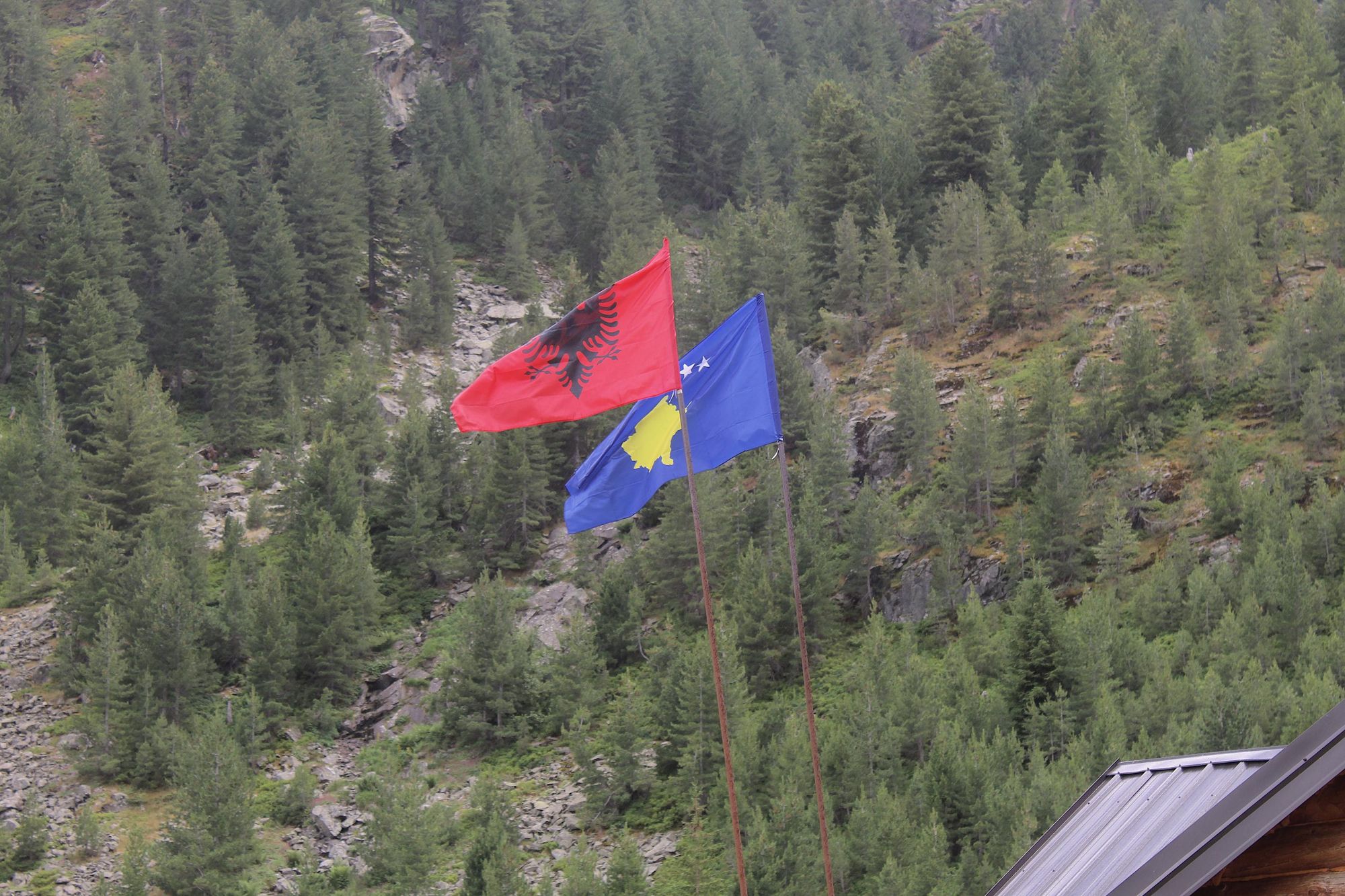 The flags of Albania and Kosovo flying alongside one another in the mountains. Photo: Stuart Kenny