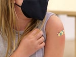 A girl shows off her bandage after receiving a vaccination at a pediatric COVID-19 vaccine clinic Nov. 10, 2021 in Happy Valley, Ore. "Think Out Loud" hosted Oregon's health officer and epidemiologist to talk about the newly formed Western Health Alliance, the partnership's vaccine recommendations and ongoing conversations about vaccines and public health. 
