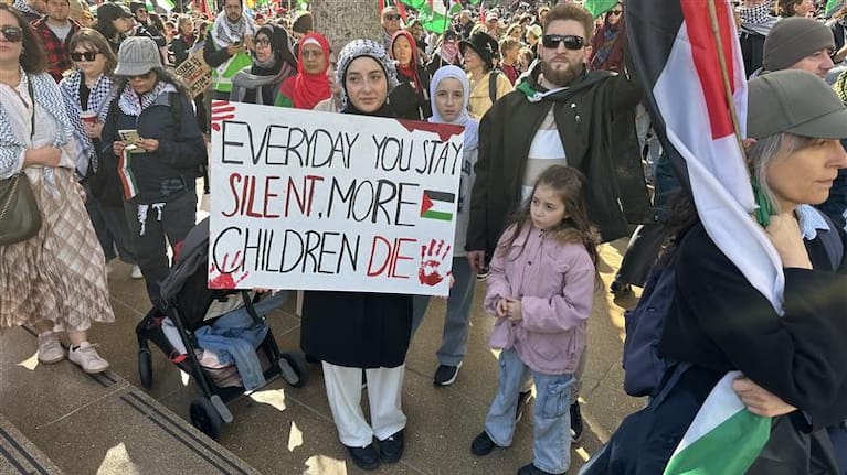 A protester holds a sign condemning the war in Gaza.  