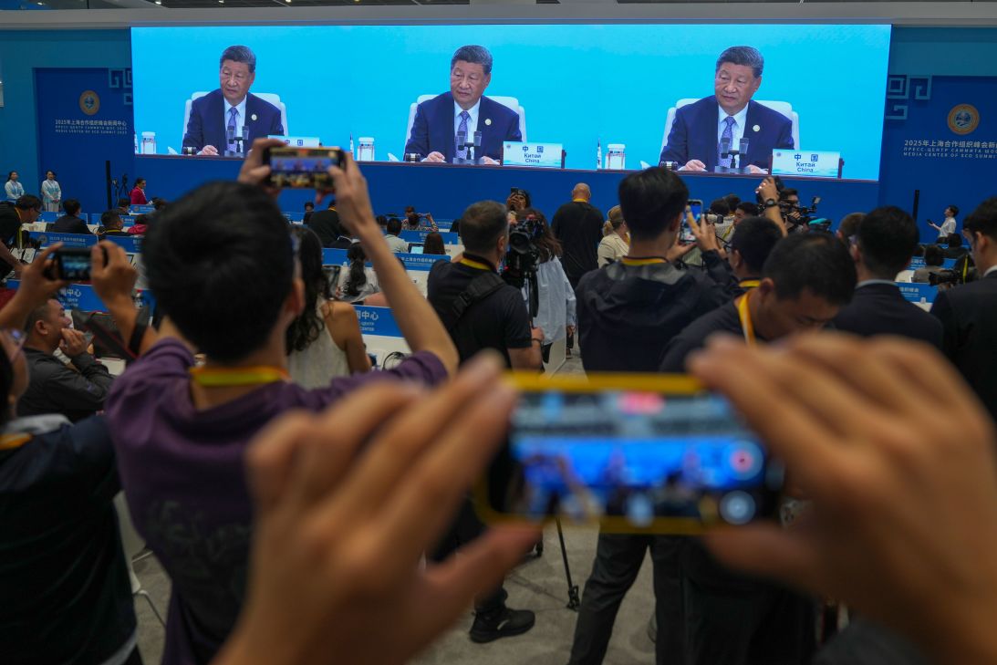 Journalists film a screen at the media center broadcasting live of Chinese President Xi Jinping, chairing the summit with leaders of member countries of the Shanghai Cooperation Organization in Tianjin, China, on Monday.