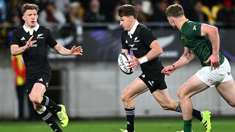 Beauden Barrett runs the ball against the Boks, with Damian McKenzie in support.