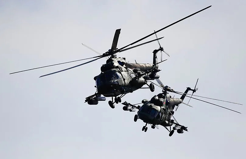 FILE: Two Belarusian military helicopters fly during military exercises, near the Volka village, 19 September 2017