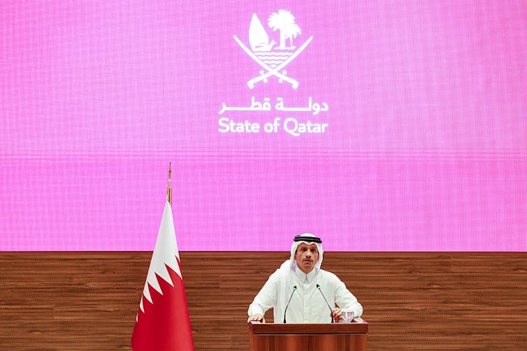 A man speaks at a lectern.