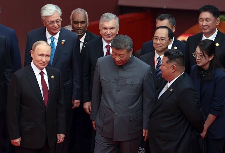 Russian president, Vladimir Putin, China's president, Xi Jinping, and North Korean leader, Kim Jong-un stand together with other world leaders.