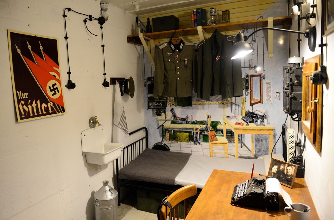 Rooms underground show life as it was during its days as a Nazi outpost. Here, military uniforms and a poster reading 