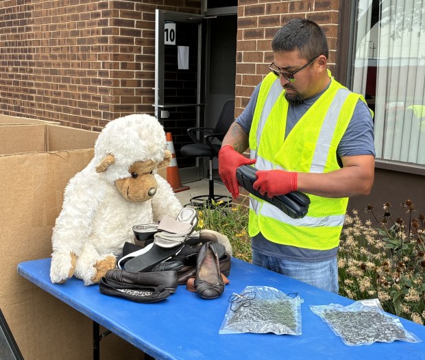 Waukegan Park District worker Oscar Zavala tends to shoes and watches over a stuffed monkey at a recycling event Saturday sponsored by the Waukegan Park District, the City of Waukegan and SWALCO. (Steve Sadin/For the Lake County News-Sun)