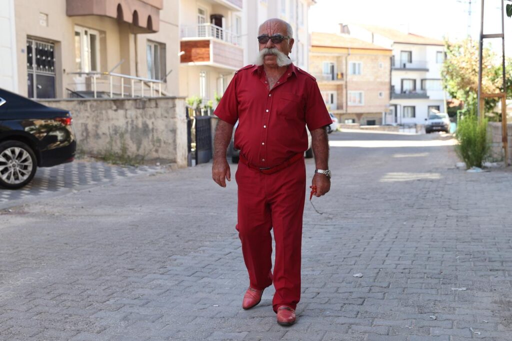 Meet the man who made color coordination a lifestyle in central Türkiye Ortacal, who coordinates his shirts, pants, shoes, and belts in the same color and is also known for his prominent mustache, is famously recognized in the city as the “colorful mustache man.” Nevsehir, Türkiye, September 17, 2025. (AA Photo)