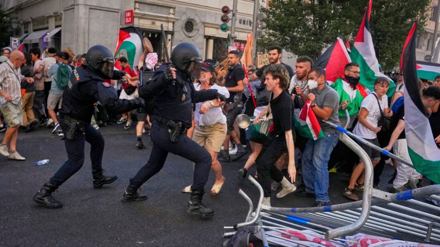 Police try to disperse protesters blocking the road. Pic: AP