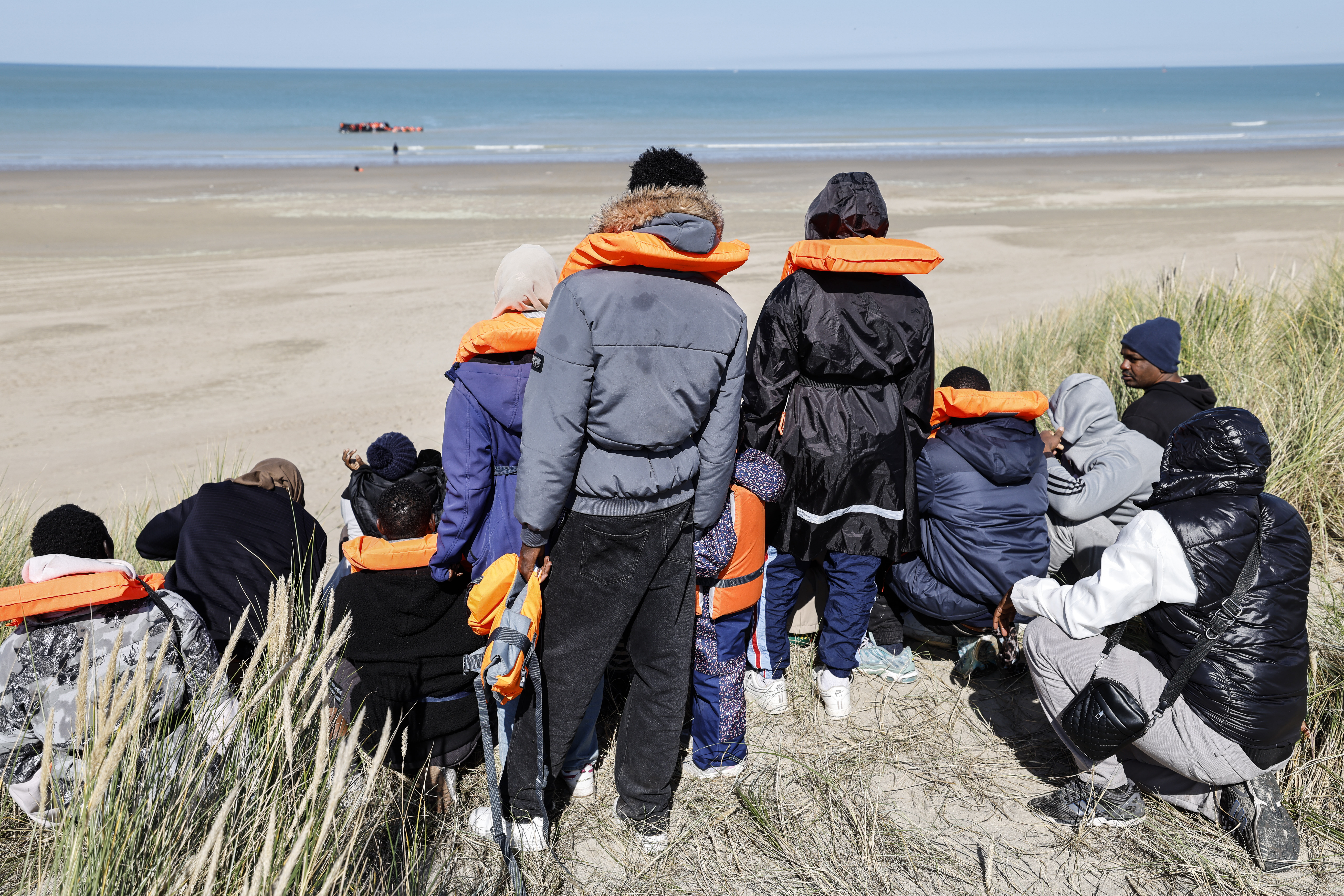 Migrants wearing life jackets waiting to board a small boat to reach Britain from Gravelines, northern France.