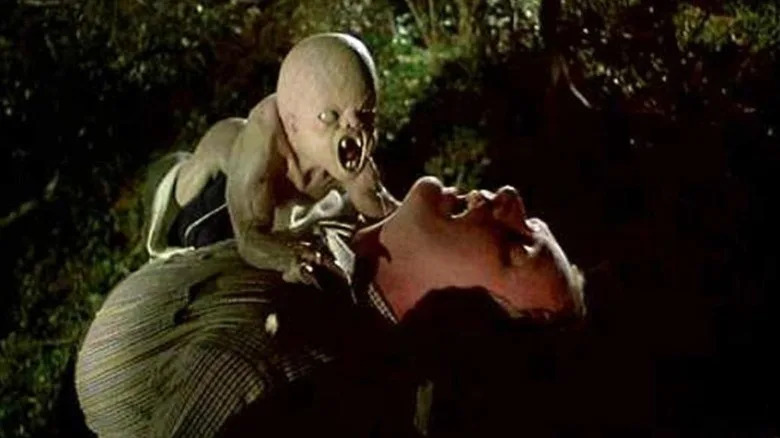A fanged baby attacking a man in a park in It's Alive