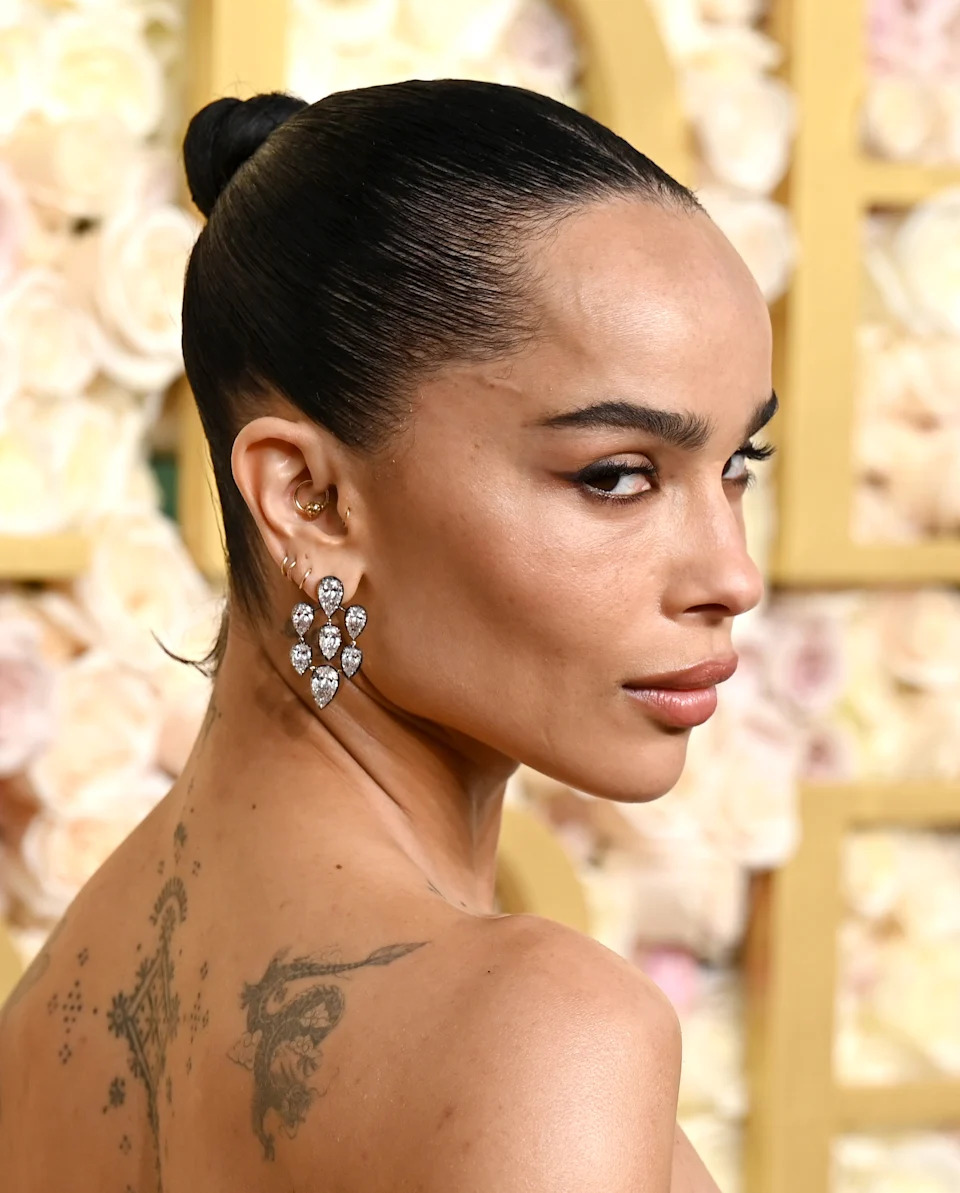 Zoë Kravitz shows off her back tattoos and earrings stack at the 82nd annual Golden Globes